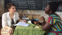 Researcher speaking with local woman in Ghana.
